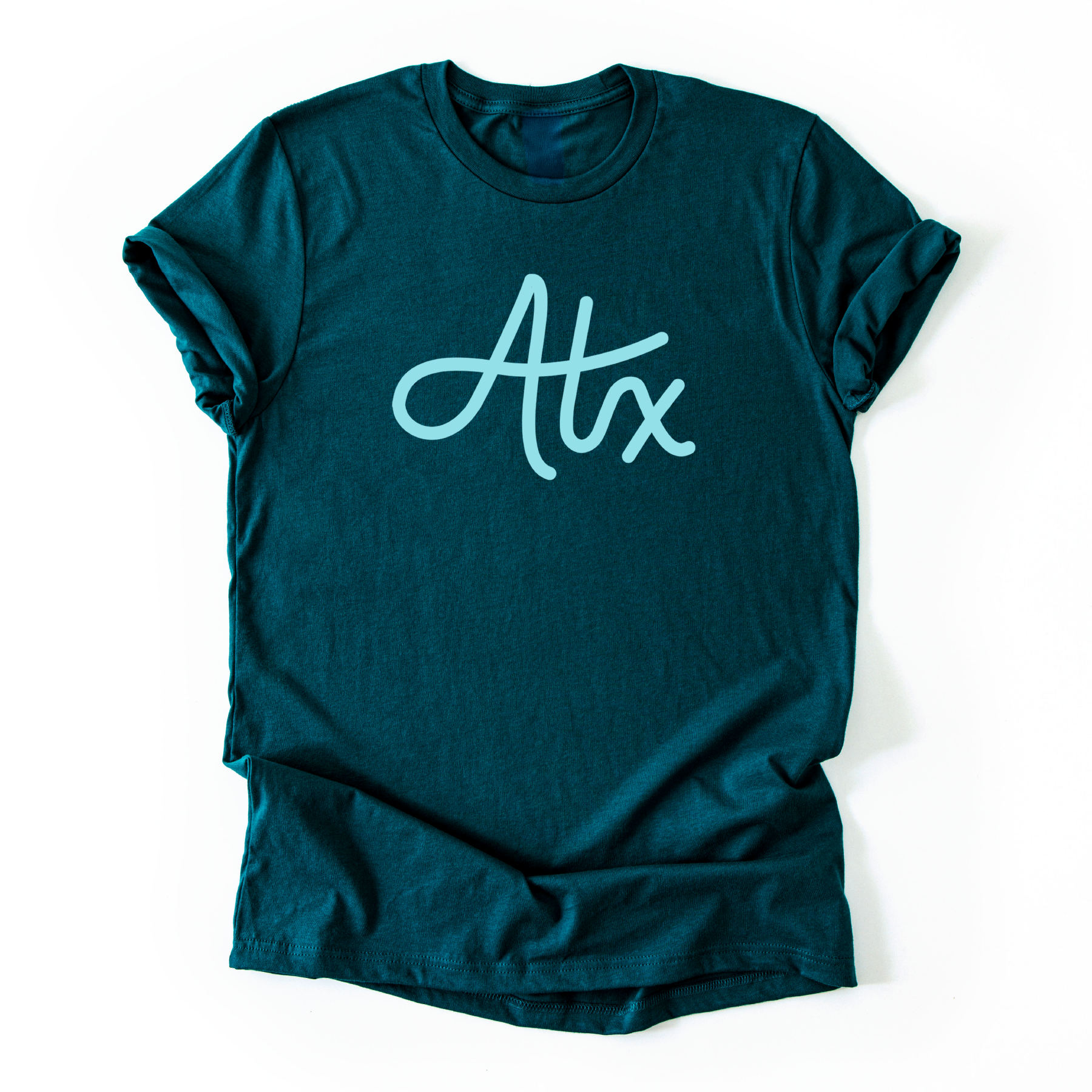 A dark teal tshirt with 'ATX' printed on it in a mint color.
