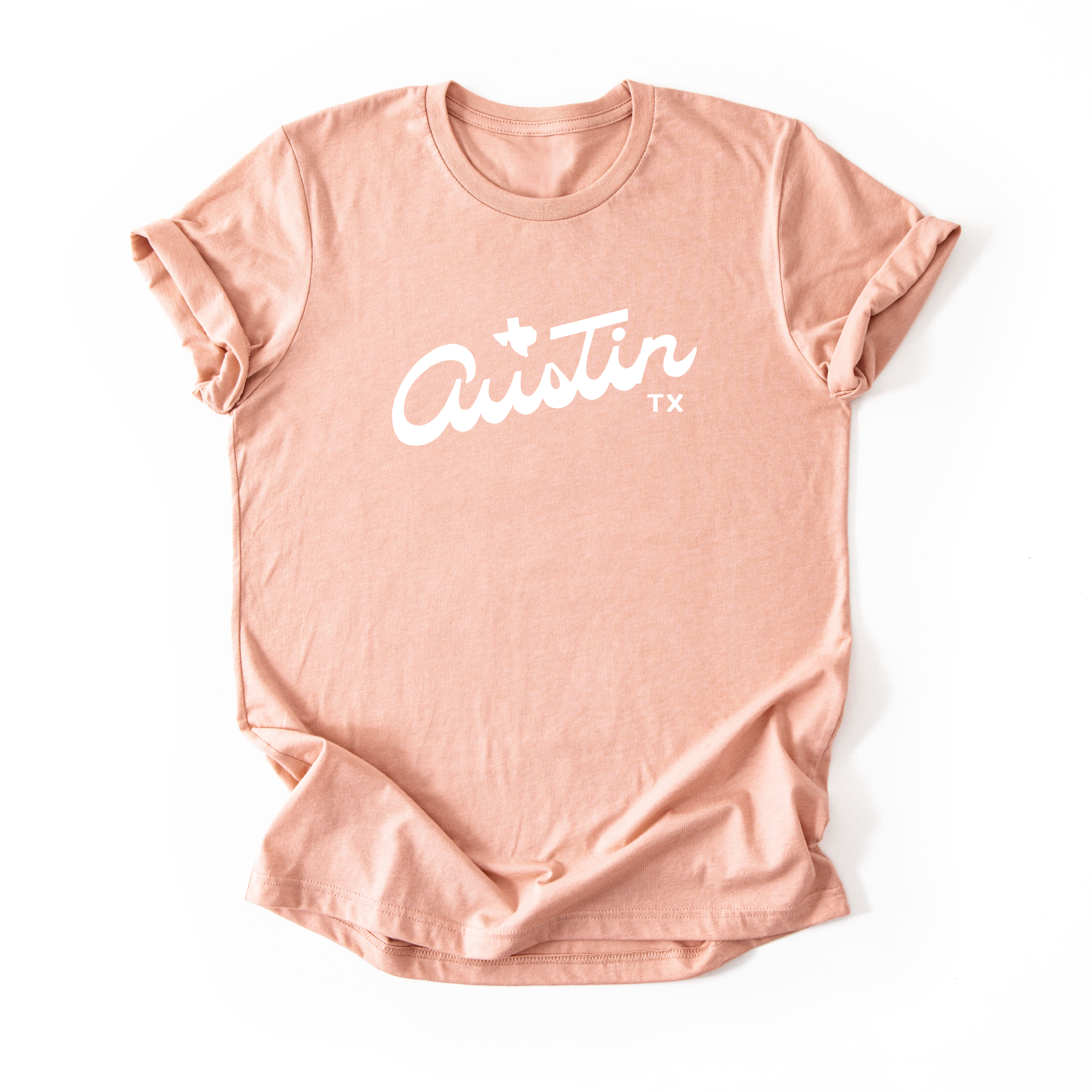 A peach t-shirt with 'Austin TX' printed on it in white.